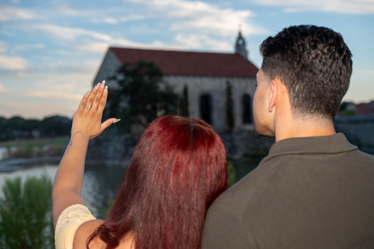 Ana shows her ring beside Luca, the chapel in front of them