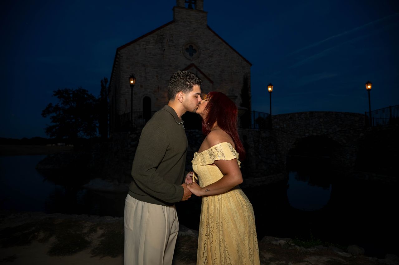 Luca and Ana kiss in front of the chapel at night