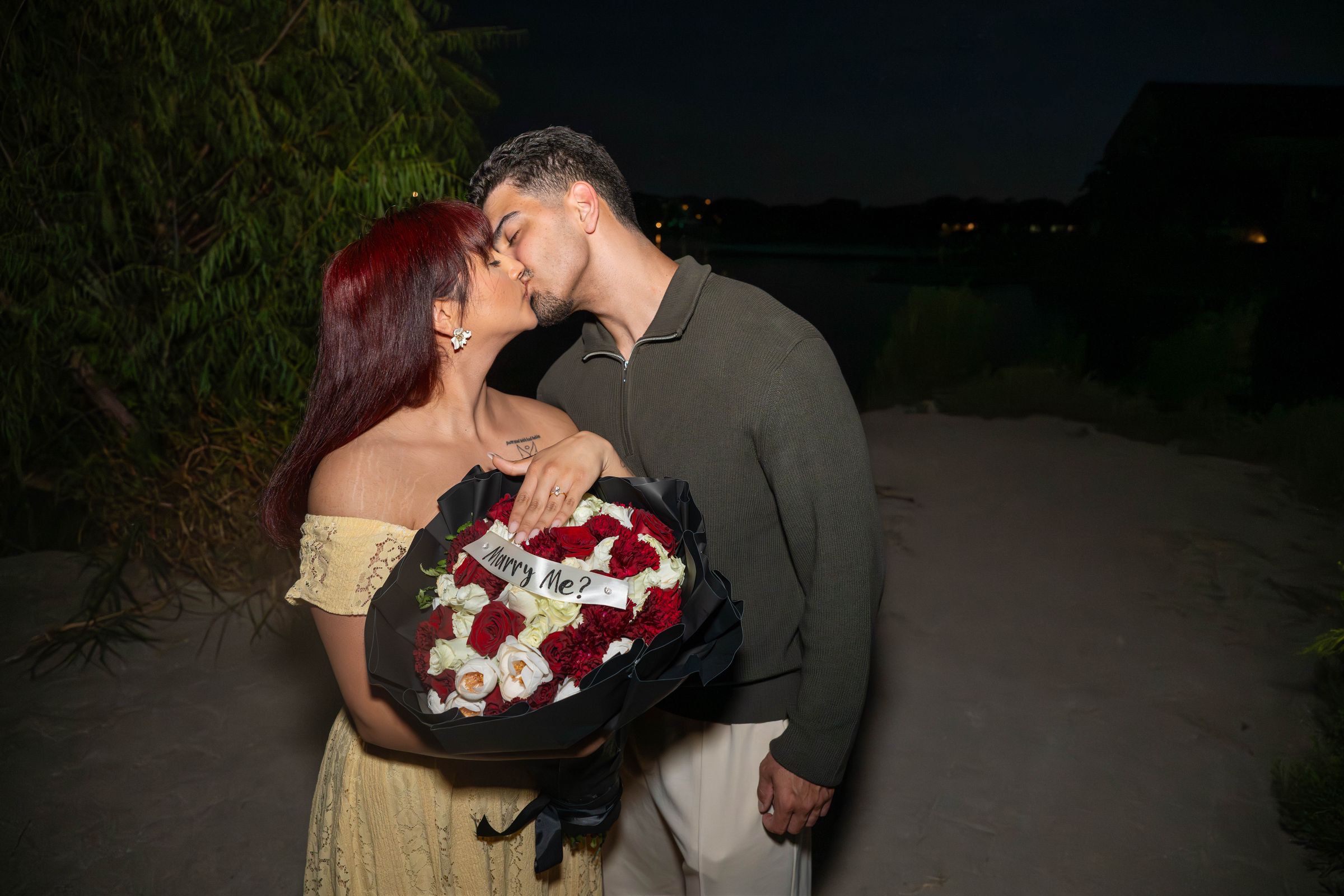Ana and Luca kiss, the Marry me bouquet between them